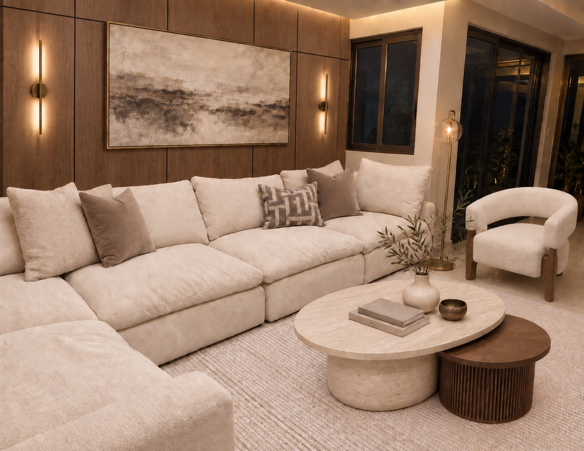Sala en tonos neutros con sofá claro, panelado de madera e iluminación cálida